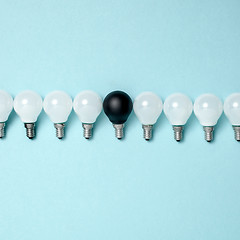 Image showing One light bulb outstanding,glowing different.business creativity idea concepts.flat lay design