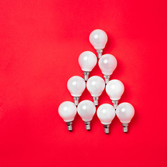 Image showing The christmas tree from lantern lamps laying on red background with copy space.