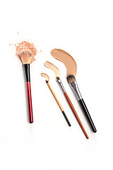 Image showing Close-up of crushed mineral shimmer powder golden color with makeup brush