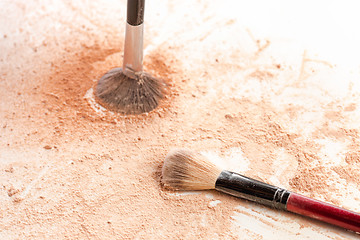 Image showing Close-up of crushed mineral shimmer powder golden color with makeup brush