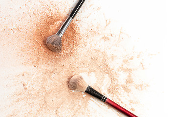 Image showing Close-up of crushed mineral shimmer powder golden color with makeup brush