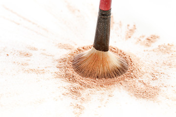 Image showing Close-up of crushed mineral shimmer powder golden color with makeup brush