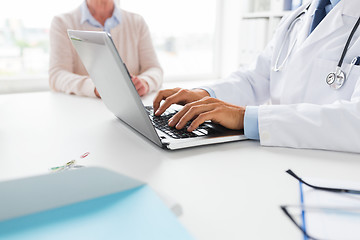 Image showing senior woman and doctor with laptop at hospital