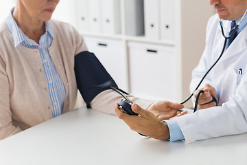 Image showing doctor with tonometer and senior woman at hospital