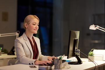 Image showing businesswoman at computer working at night office