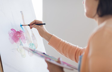 Image showing artist with palette and brush painting at studio