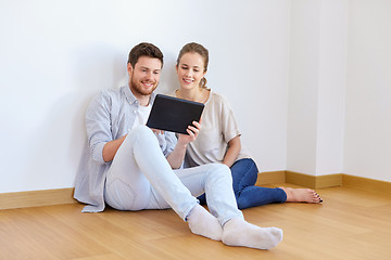 Image showing happy couple with tablet pc computer at new home
