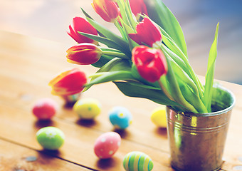 Image showing tulip flowers in bucket and easter eggs on table