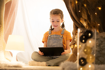 Image showing little girl with tablet pc in kids tent at home