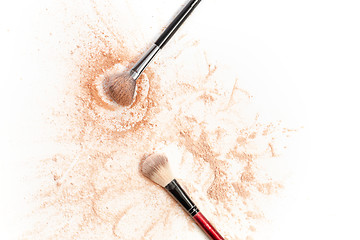 Image showing Close-up of crushed mineral shimmer powder golden color with makeup brush