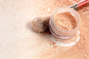 Image showing Close-up of crushed mineral shimmer powder golden color with makeup brush