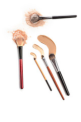 Image showing Close-up of crushed mineral shimmer powder golden color with makeup brush