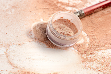 Image showing Close-up of crushed mineral shimmer powder golden color with makeup brush