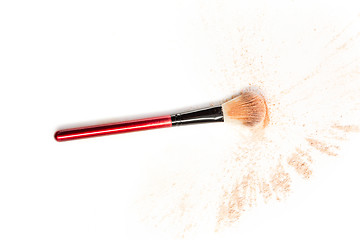 Image showing Close-up of crushed mineral shimmer powder golden color with makeup brush