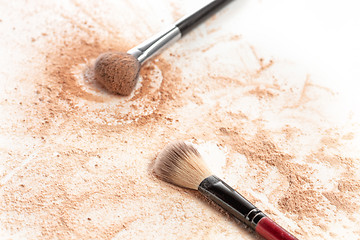 Image showing Close-up of crushed mineral shimmer powder golden color with makeup brush