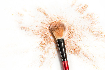 Image showing Close-up of crushed mineral shimmer powder golden color with makeup brush