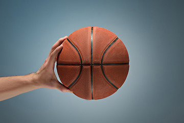 Image showing Low key shot of a hand holding a basket ball