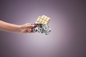 Image showing Hands of a woman holding a tile of chocolate