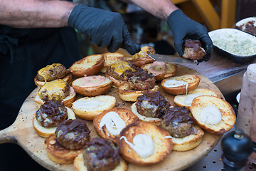 Image showing Chef making beef burgers outdoor on open kitchen international food festival event.