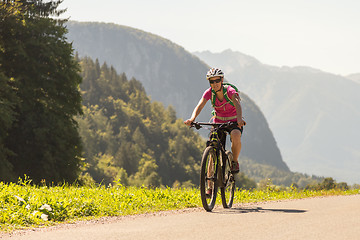 Image showing Active sporty woman riding mountain bike in nature.