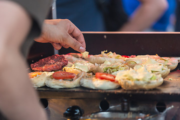 Image showing Chef making beef burgers outdoor on open kitchen international food festival event.