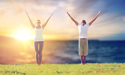 Image showing couple making yoga exercises outdoors