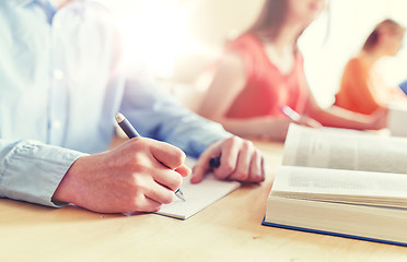 Image showing close up of student writing to notebook at school