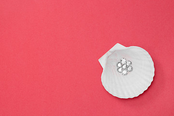 Image showing Shiny gems in a seashell on pink background