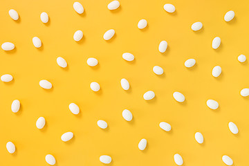 Image showing White chocolate candies on yellow background