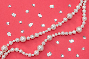 Image showing Pearl necklace and shiny gems on pink background