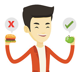 Image showing Man choosing between hamburger and cupcake.