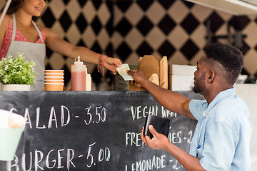 Image showing african american man paying money at food truck