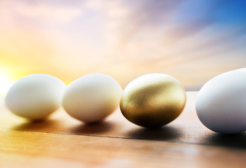 Image showing close up of golden and white easter eggs on wood