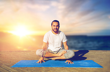 Image showing man doing yoga scale pose outdoors