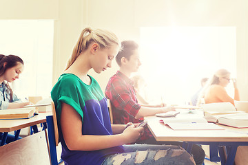 Image showing student girl with smartphone texting at school