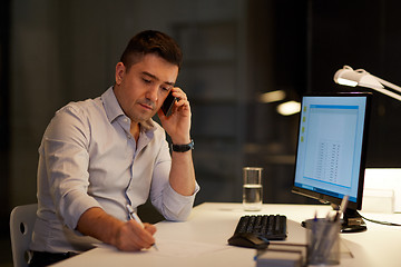 Image showing businessman calling on sartphone at night office