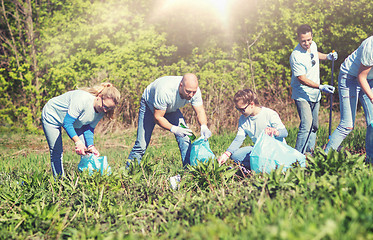 Image showing volunteers with garbage bags cleaning park area