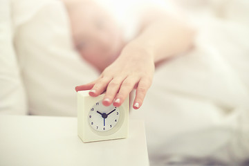 Image showing close up of woman with alarm clock in bed at home