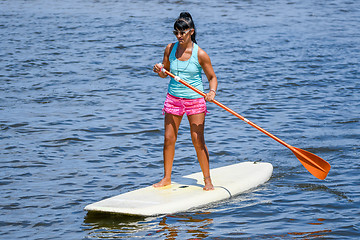 Image showing Woman stand up paddleboarding