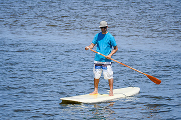 Image showing Man stand up paddleboarding