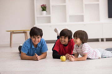 Image showing boys having fun with an apple on the floor