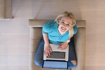 Image showing Young woman using laptop at home top view