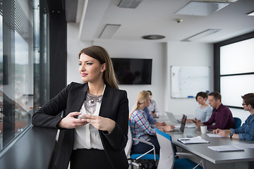 Image showing Business Girl Standing In A Modern Building Near The Window With