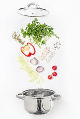 Image showing Assorted fresh vegetables falling into a bowl, on white background