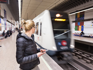 Image showing Woman with a cell phone waiting for metro.