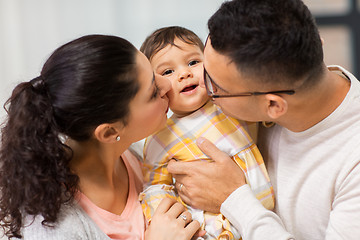 Image showing happy mother and father kissing baby daughter
