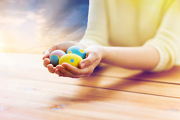 Image showing close up of woman hands with colored easter eggs