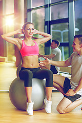 Image showing smiling man and woman with exercise ball in gym