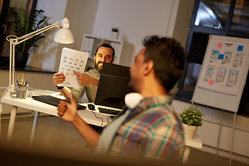 Image showing creative man showing papers to colleague at office