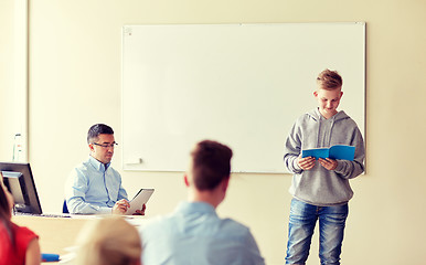 Image showing student boy with notebook and teacher at school